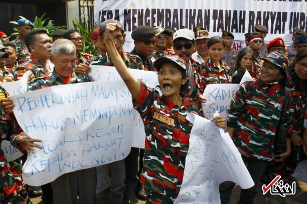 تصاویر : معترضان در اندونزی از سفارت مالزی بالا رفتند