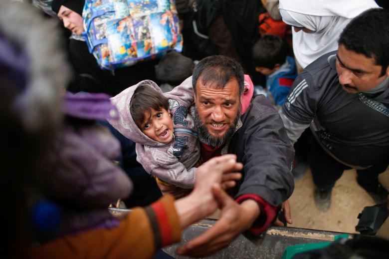 عکس/تقلای مرد عراقی و فرزندش برای فرار از دست داعش